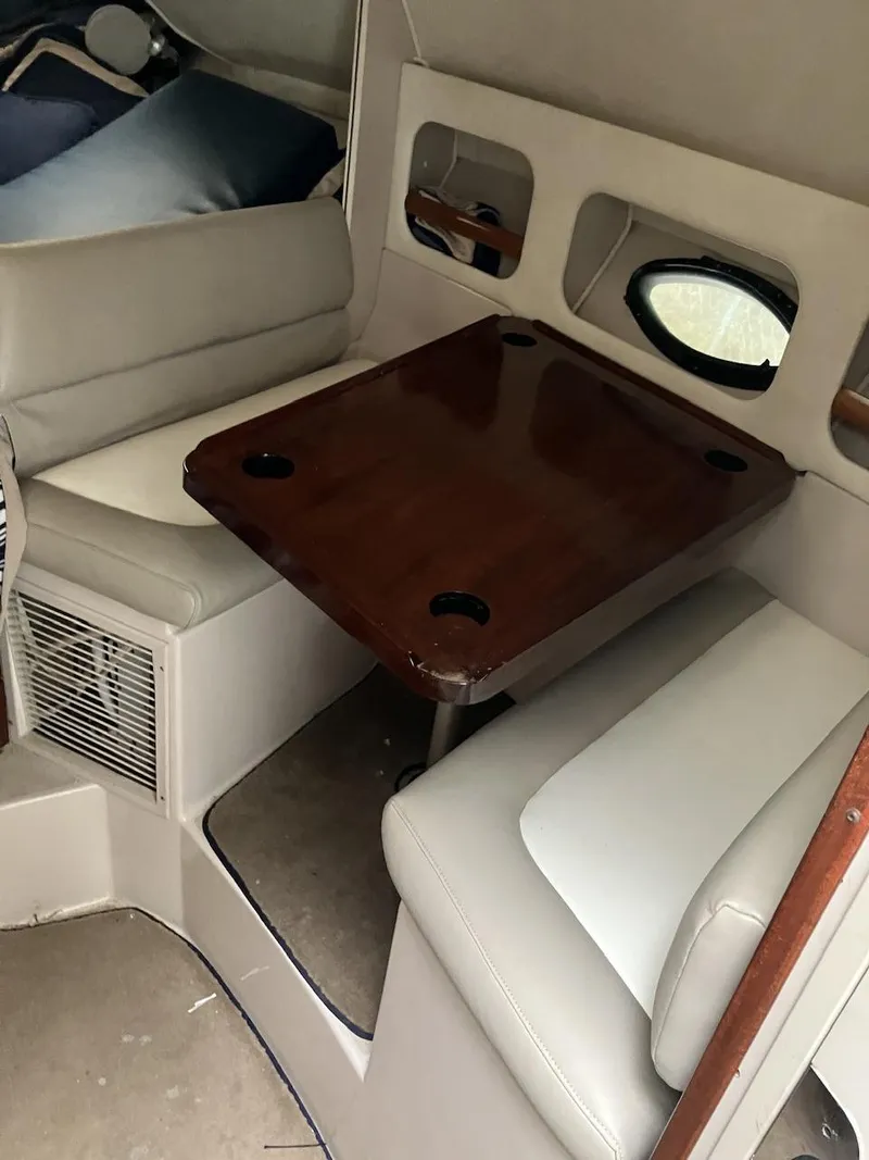 Slide: The Image of Interior of 2001 Doral 270 SC boat with wooden table and cushioned seating. - 9