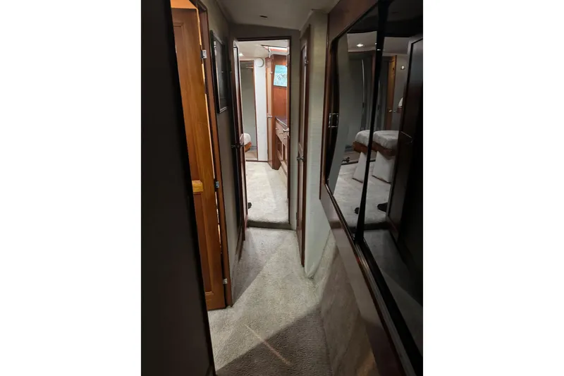 Slide: The Image of Interior hallway of 1987 Ocean Yachts 63 Convertible Manns, featuring wood paneling and carpet. - 10