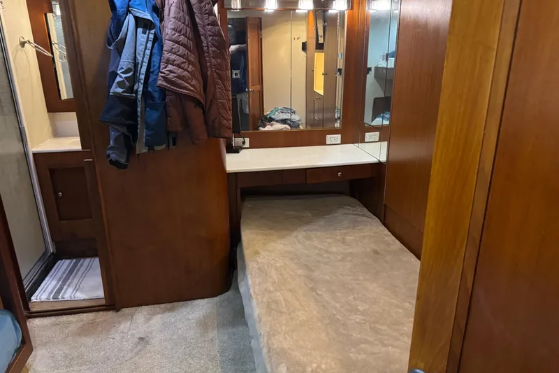 Slide: The Image of Interior of 1987 Ocean Yachts 63 Convertible Manns, featuring wood paneling and a cozy bed. - 13