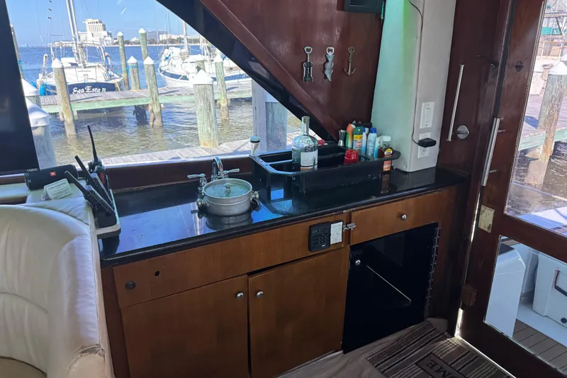 Slide: The Image of Interior of 1987 Ocean Yachts 63 Convertible Manns with kitchenette and marina view. - 18