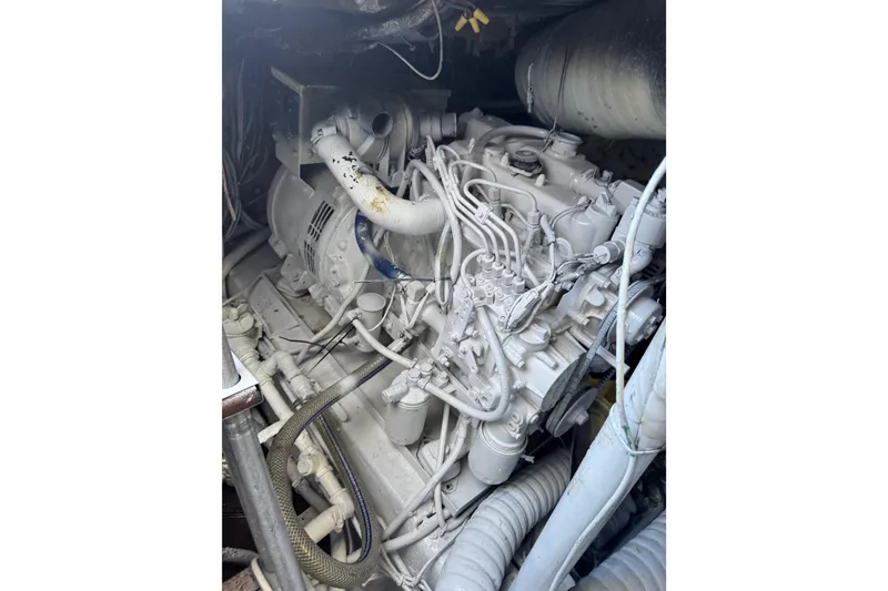 Slide: The Image of Engine room of 1987 Ocean Yachts 63 Convertible Manns, showcasing complex machinery and hoses. - 19