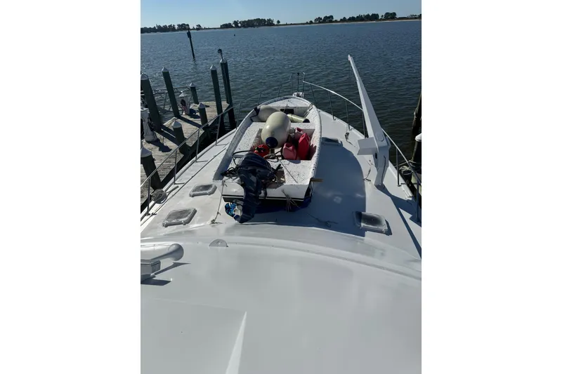 Slide: The Image of 1987 Ocean Yachts 63 Convertible Manns on water, docked with equipment on deck. - 23