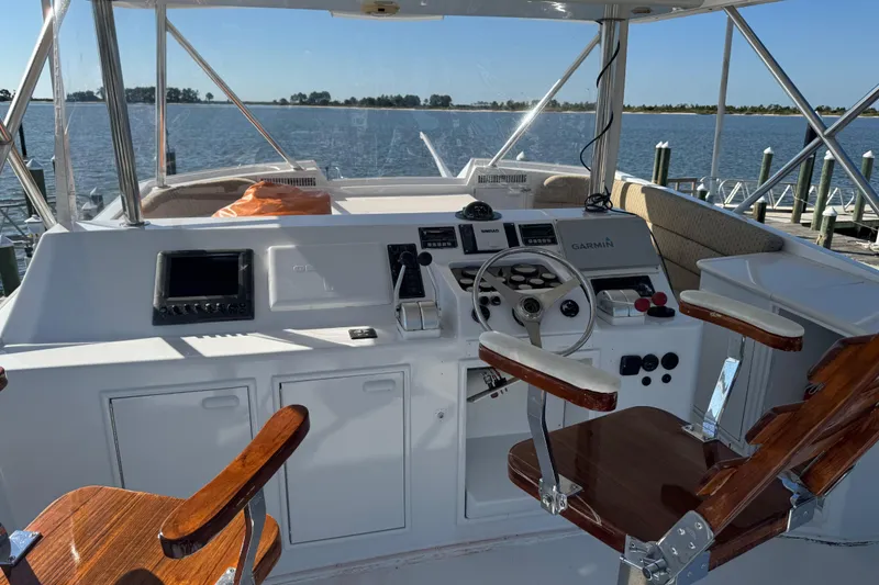 Slide: The Image of 1987 Ocean Yachts 63 Convertible Manns helm with navigation equipment and wooden chairs. - 25