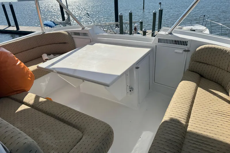 Slide: The Image of 1987 Ocean Yachts 63 Convertible Manns interior with seating and table, overlooking marina. - 24