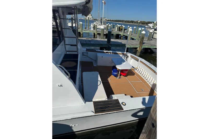 Slide: The Image of 1987 Ocean Yachts 63 Convertible Manns at dock, featuring spacious deck and seating area. - 27