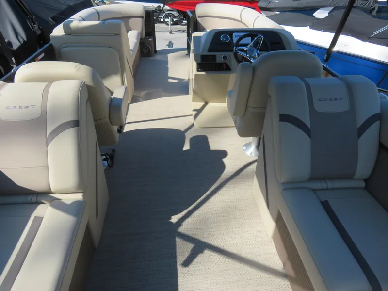 Slide: The Image of 2023 Crest Classic LX 220 boat interior with beige seating and modern dashboard. - 3