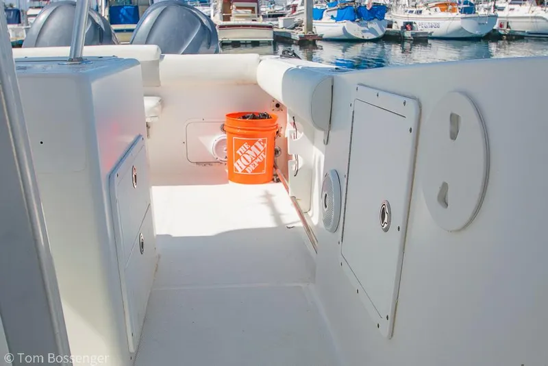 Slide: The Image of 2010 Sea Hunt Gamefish 29 boat interior with storage compartments and an orange bucket. - 22