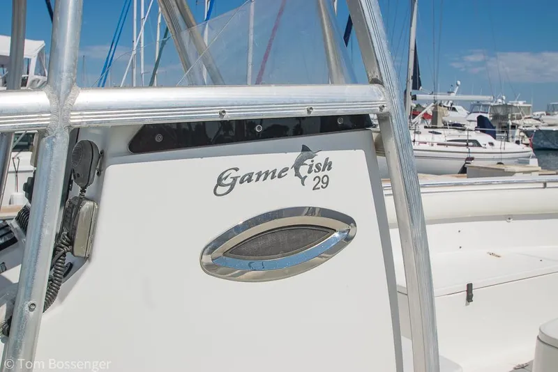 Slide: The Image of Sea Hunt Gamefish 29 boat, 2010 model, docked in a marina under clear blue skies. - 4