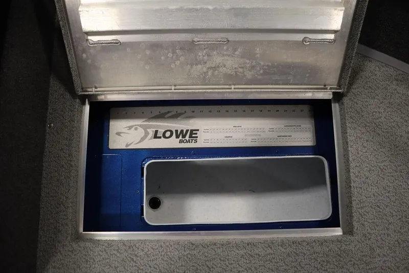 Slide: The Image of 2025 Lowe 1775 FM WT boat storage compartment with integrated measuring ruler. - 21