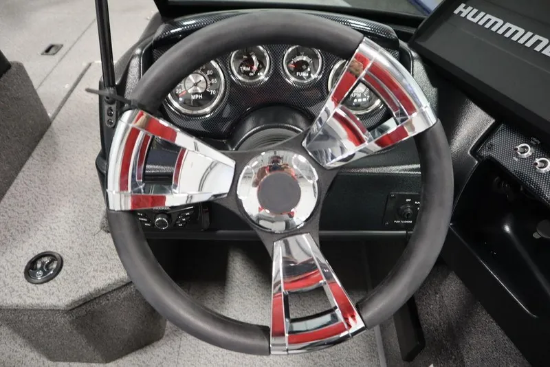 Slide: The Image of Steering wheel of 2025 Lowe 1775 FM WT boat with chrome accents and dashboard instruments. - 22
