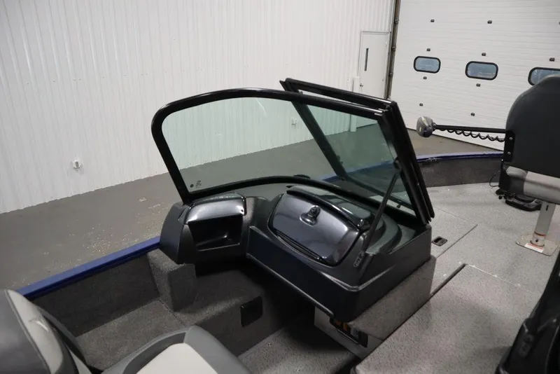 Slide: The Image of 2025 Lowe 1775 FM WT boat interior with windshield and seating in a garage setting. - 31