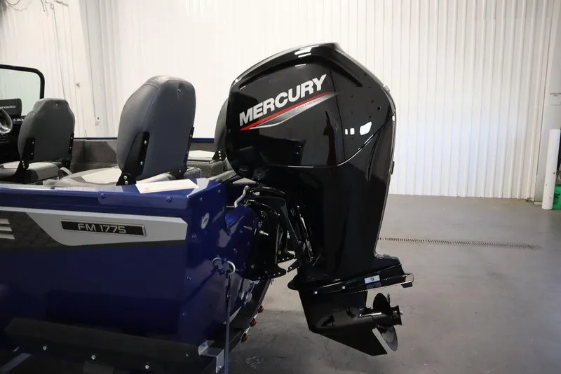 Slide: The Image of 2025 Lowe 1775 FM WT boat with Mercury outboard motor in a garage setting. - 44