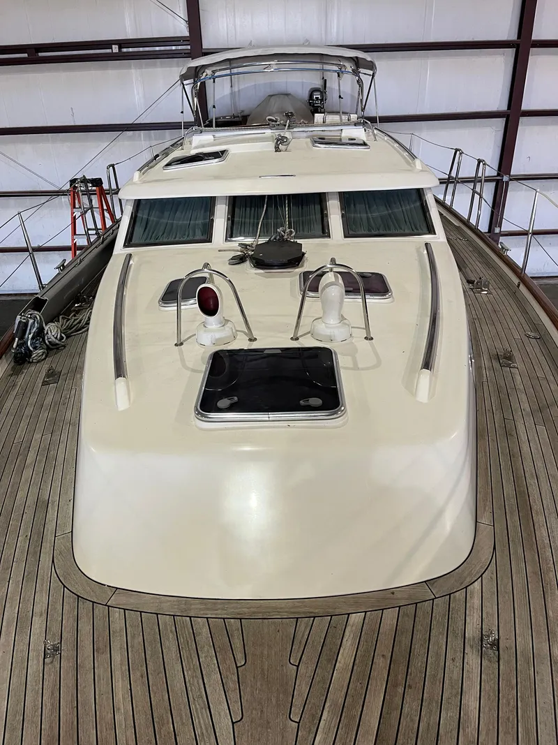 Slide: The Image of 2003 Fantasi 44 Pilot House yacht with wooden deck in indoor storage. - 17