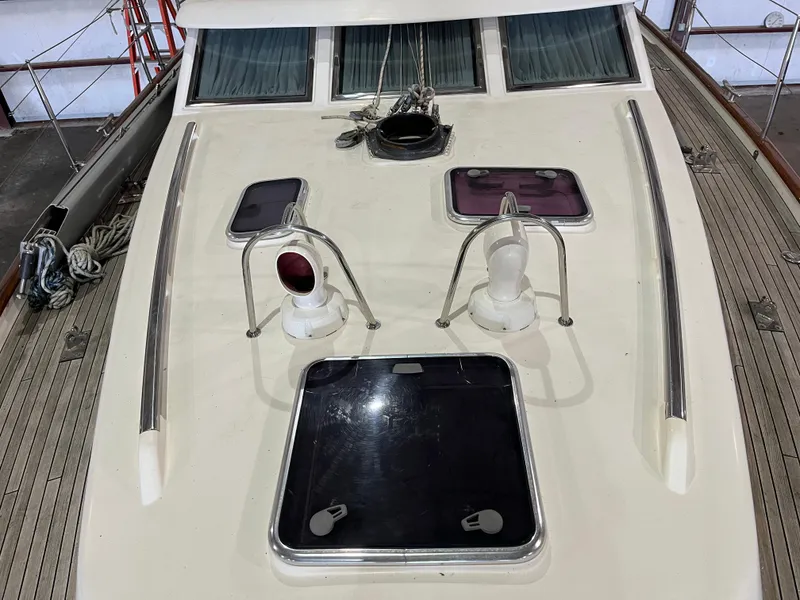 Slide: The Image of 2003 Fantasi 44 Pilot House yacht deck with hatches and railings in a marina setting. - 18