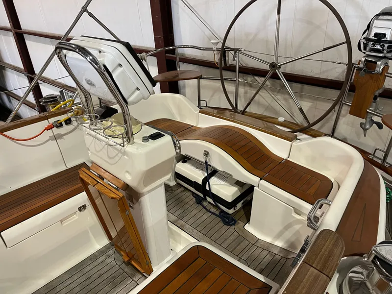 Slide: The Image of 2003 Fantasi 44 Pilot House yacht cockpit with wooden seating and steering wheel. - 24
