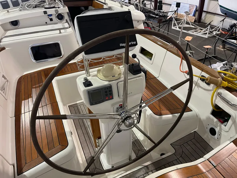 Slide: The Image of 2003 Fantasi 44 Pilot House yacht cockpit with wooden deck and steering wheel. - 26