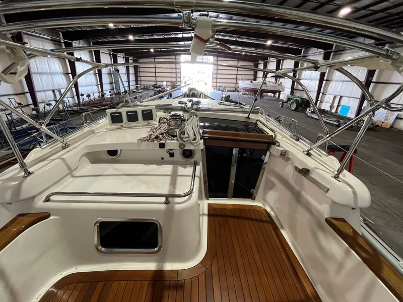 Slide: The Image of 2003 Fantasi 44 Pilot House yacht interior with wooden deck in a storage facility. - 37