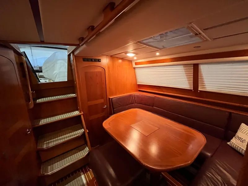 Slide: The Image of Luxurious interior of 2003 Fantasi 44 Pilot House yacht with wooden dining area and stairs. - 40