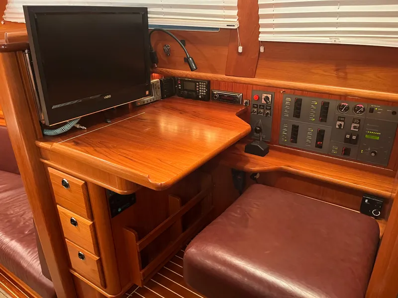 Slide: The Image of Navigation station of 2003 Fantasi 44 Pilot House yacht with wooden desk and control panel. - 44