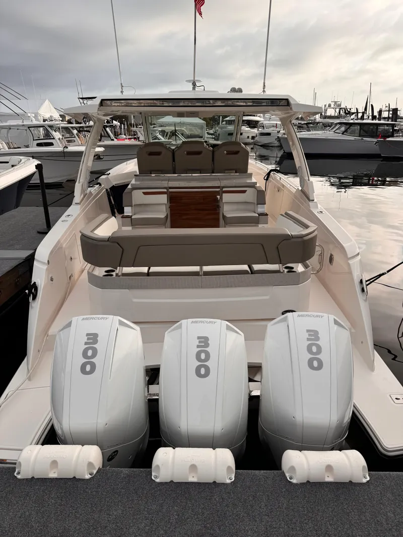 Slide: The Image of 2023 Tiara Yachts 38 LS with triple outboard engines at a marina. - 5