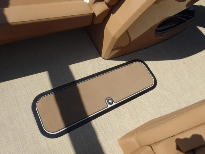 Slide: The Image of 2025 Harris Solstice 250 boat interior with tan flooring and storage compartment. - 7