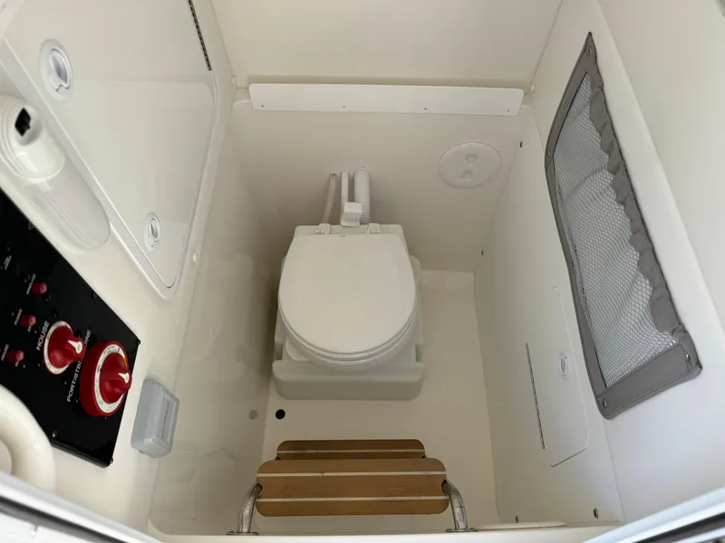 Slide: The Image of 2017 Regulator 25 CC boat interior with toilet and control panel. - 12