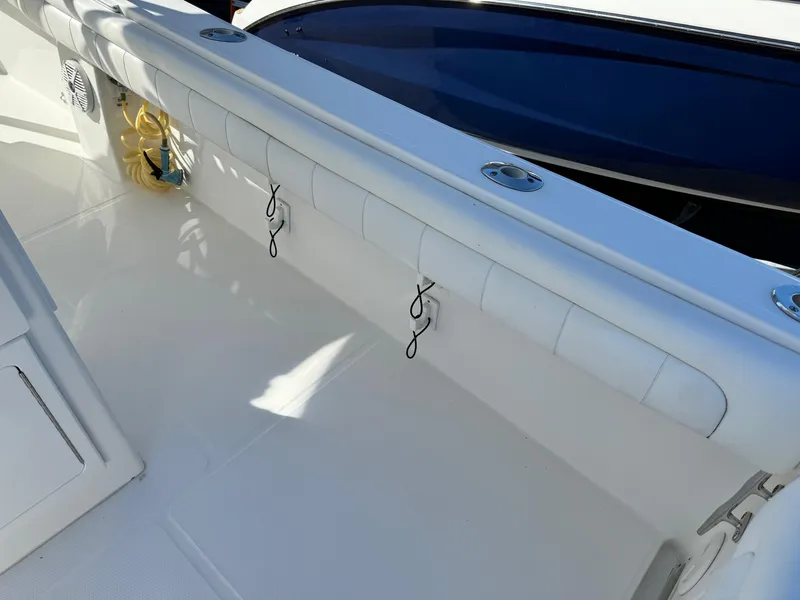 Slide: The Image of 2017 Regulator 25 CC boat interior with white seating and storage hooks. - 20