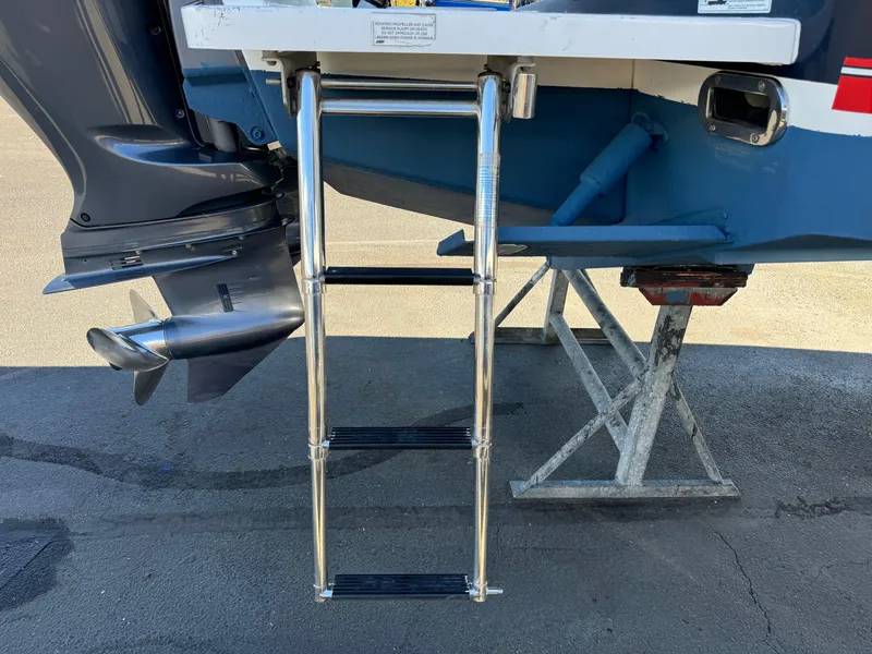 Slide: The Image of 2017 Regulator 25 CC boat with stainless steel swim ladder and outboard motor. - 25