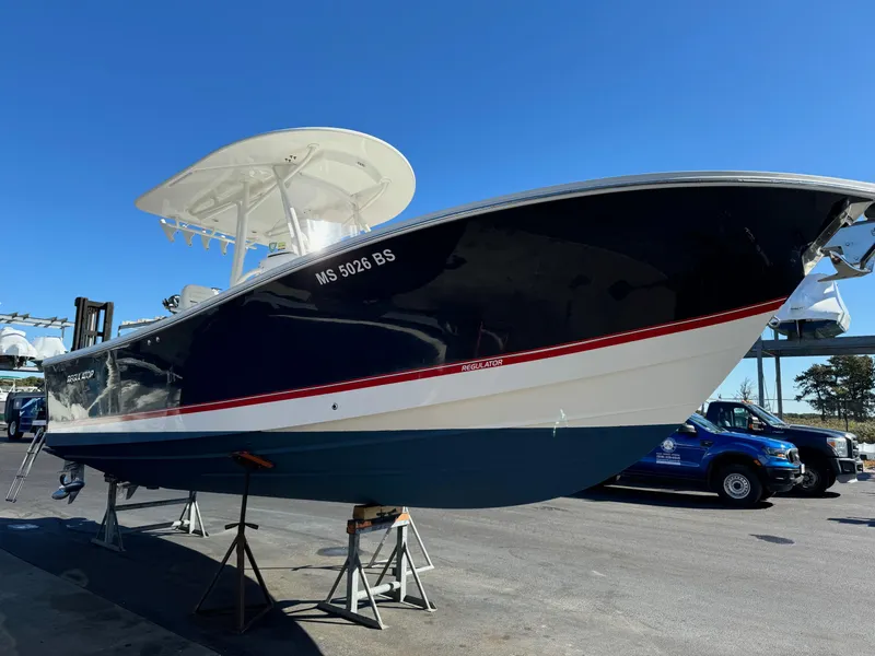 Slide: The Image of 2017 Regulator 25 CC boat on display, blue hull, white and red accents. - 3