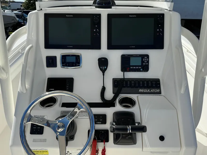 Slide: The Image of 2017 Regulator 25 CC boat dashboard with dual displays and steering wheel. - 9