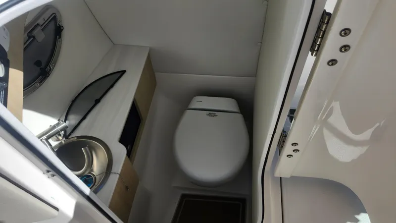 Slide: The Image of 2025 Regal LX6 boat interior bathroom with toilet and sink. - 14