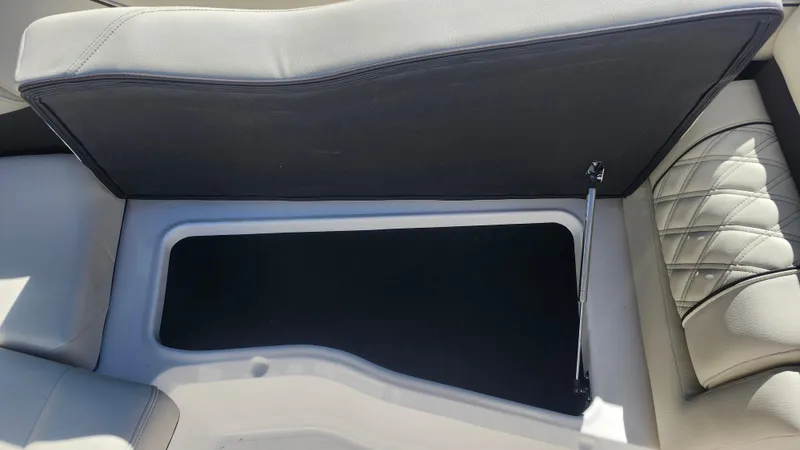 Slide: The Image of 2025 Regal LX6 boat storage compartment with cushioned seating. - 17