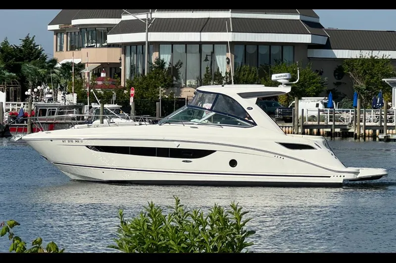 The Image of 2019 Sea Ray 350 Sundancer yacht docked near waterfront buildings. - 0