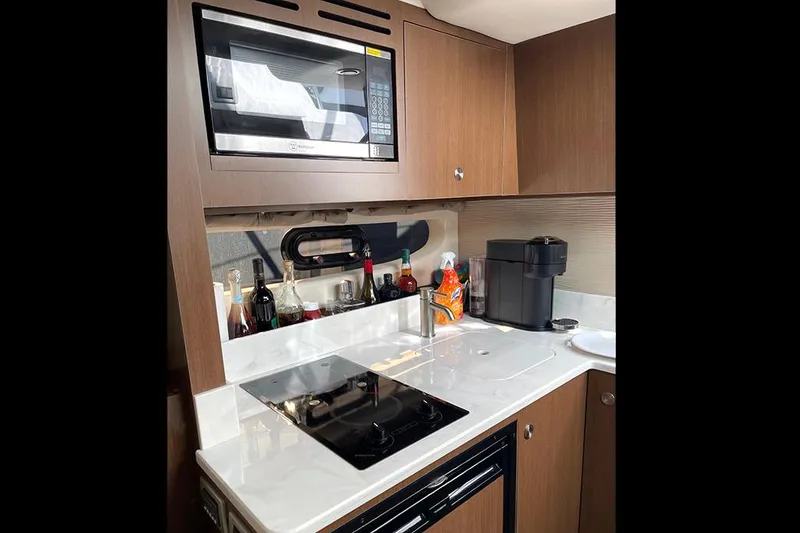 Slide: The Image of Modern kitchen in 2019 Sea Ray 350 Sundancer yacht with microwave and stovetop. - 14