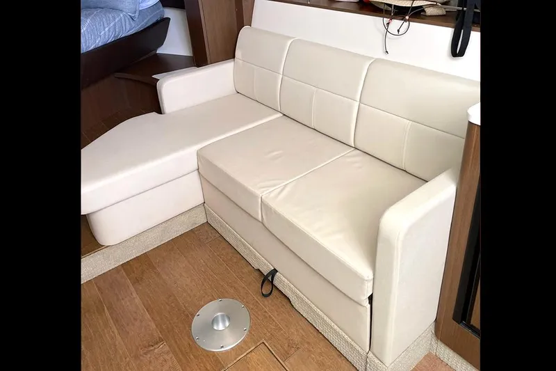 Slide: The Image of 2019 Sea Ray 350 Sundancer interior with beige leather seating and wooden flooring. - 15