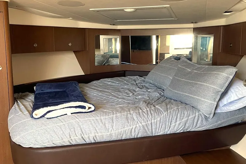 Slide: The Image of 2019 Sea Ray 350 Sundancer cabin with cozy bed and modern interior design. - 16