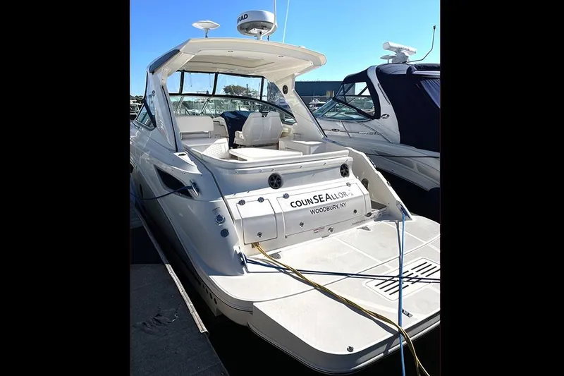 Slide: The Image of 2019 Sea Ray 350 Sundancer yacht docked, showcasing sleek design and spacious deck. - 2