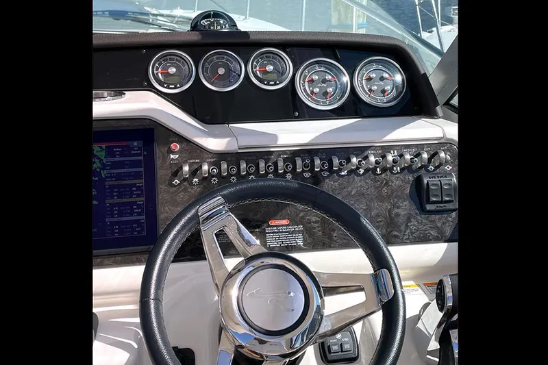 Slide: The Image of 2019 Sea Ray 350 Sundancer dashboard with gauges, controls, and steering wheel. - 5