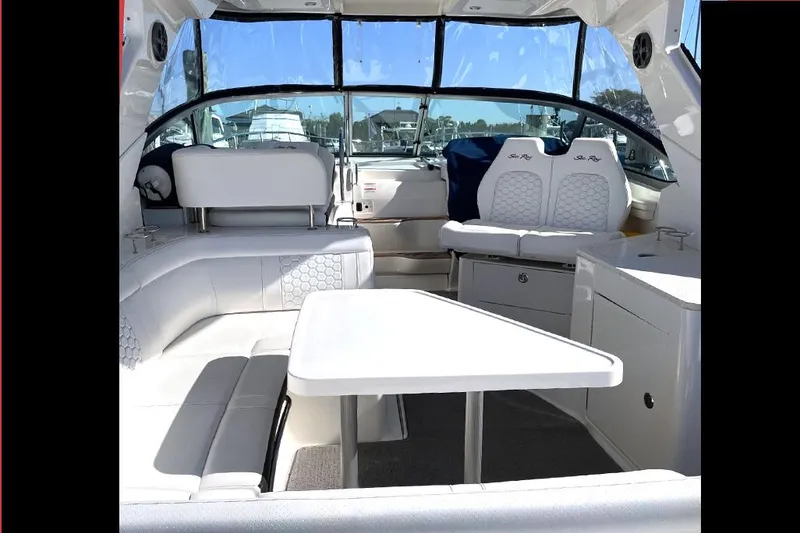 Slide: The Image of 2019 Sea Ray 350 Sundancer interior with white seating and table, showcasing luxury design. - 9