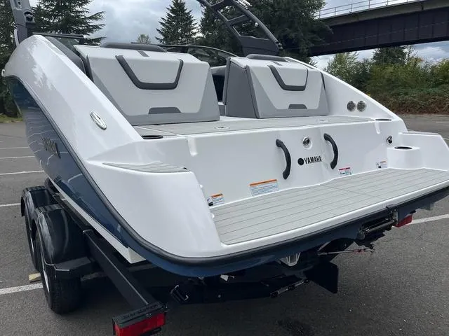 Slide: The Image of 2025 Yamaha Boats AR220, rear view, parked outdoors, showcasing sleek design and seating. - 8