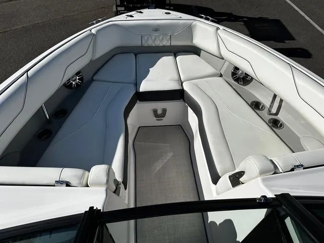 Slide: The Image of 2021 Regal LS4 boat interior with white cushioned seating and cup holders. - 7