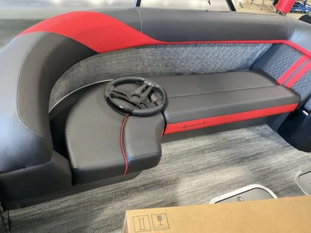 Slide: The Image of 2025 Bennington 24 MFB boat interior with red and gray seating and steering wheel. - 16