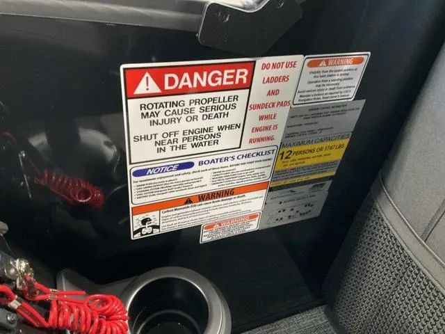 Slide: The Image of Warning labels on a 2025 Bennington 24 MFB boat, highlighting safety precautions. - 21
