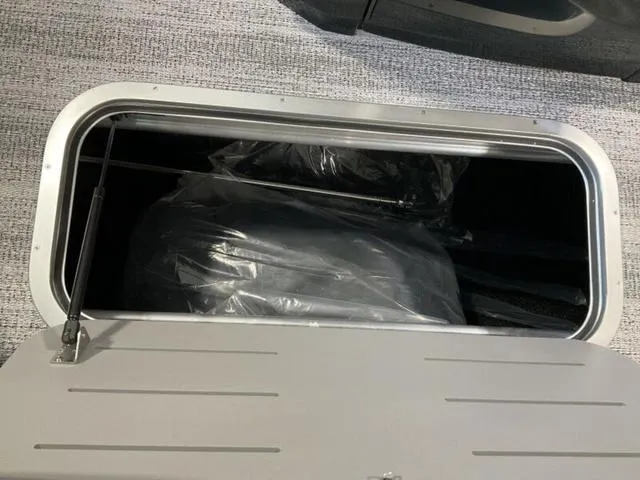 Slide: The Image of Storage compartment of 2025 Bennington 24 MFB boat, open with visible contents. - 22