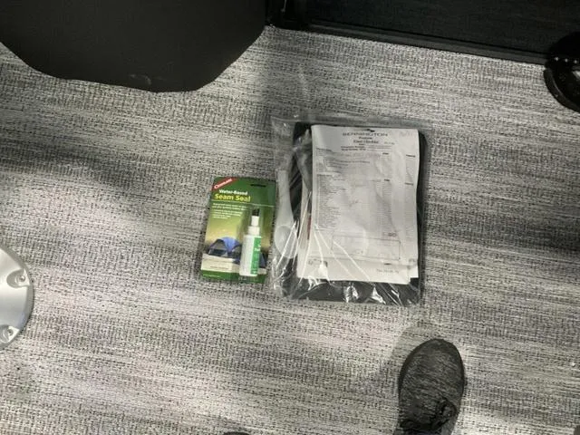 Slide: The Image of Bennington 24 MFB 2025 documents and seam seal kit on carpeted floor. - 24