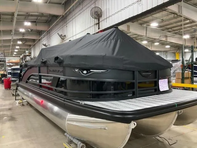 Slide: The Image of 2025 Bennington 24 MFB pontoon boat in a warehouse, covered with a black tarp. - 28