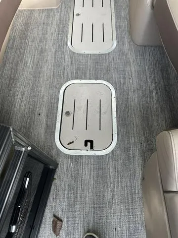 Slide: The Image of Interior flooring of 2025 Bennington 25 QSBA boat with storage compartments. - 10