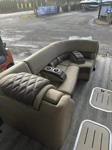 Slide: The Image of 2025 Bennington 25 QSBA luxury boat seating with cup holders, docked outdoors. - 5