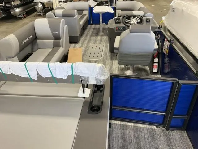 Slide: The Image of 2025 Bennington 22SSB-SPS boat interior with gray seating and a box on the floor. - 12