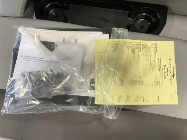 Slide: The Image of 2025 Bennington 22SSB-SPS pontoon boat in a warehouse, partially wrapped in bubble wrap. - 25